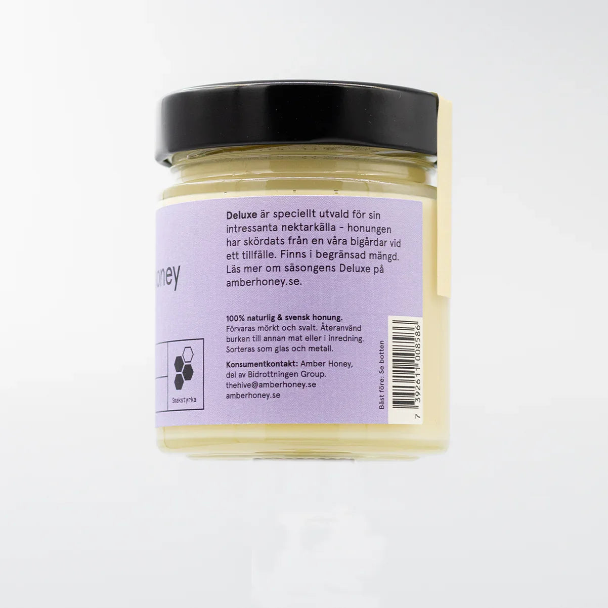 Glasburk med svensk naturlig honung, lila etikett, svart lock, produktinformation.