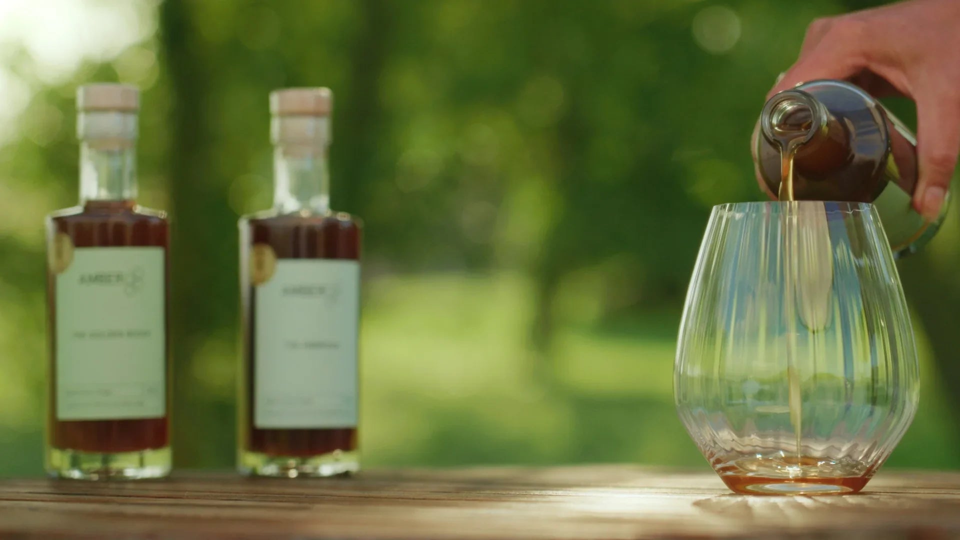 Honungsvinäger hälls i glas, två flaskor honungsvinäger utomhus, naturlig bakgrund